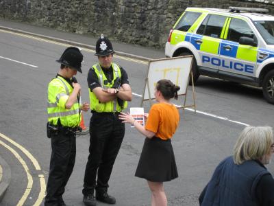 Emily convinces local police officers that Fringe stickers will completely set off their uniforms.