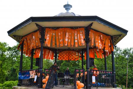 Charlie Hughes performs on the orange-bedecked bandstand