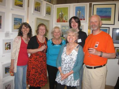  Fringe Vice Chair, Maria Carnegie, Fringe Secretary Pam Mason, Green Man volunteers Wendy Sheville and Charles Denton (behind), The Green Man's Events Manager, Caroline Small, and Fringe Chair Keith Savage against a backdrop of pictures at The Green Man Gallery.