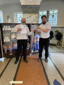 Luke Bates and Alfie Tomkinson of Buxton Visitor Centre receive a thank you letter and a Terry's Chocolate Orange from Morrisons for hosting their Hot Spot (credit: Linda Rolland 2022)