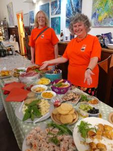 Fringe committee members Pam and Carole show off the spread at the Programme Party 2022.
