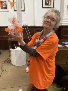 Jeanette Hamilton helps decorate the stage with orange flowers (MK) 